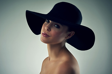 Image showing Shes got that beauty to cause a stir. Studio portrait of a beautiful young woman wearing a hat against a grey background.