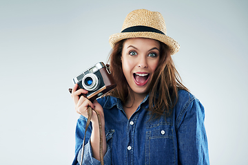 Image showing I cant picture a more exciting moment. Studio portrait of a young woman using a vintage camera against a grey background.