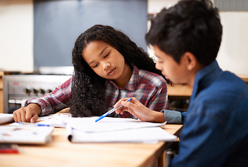 Image showing Solving their homework together. Shot of two young students studying together in a classroom.