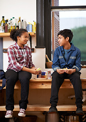 Image showing This is delicious. Shot of two young teenagers enjoying a snack together in the kitchen.