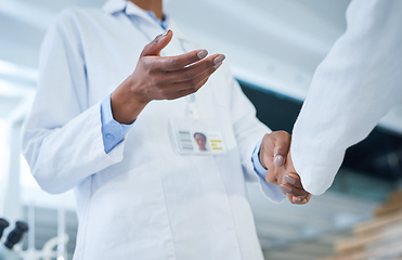 Image showing The biggest deal in research and development. Shot of two unrecognisable scientists shaking hands in a laboratory.