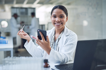 Image showing Our cruelty free cosmetics keep you looking good minus the guilt. Shot of a young scientist applying makeup using a smartphone while conducting research in a laboratory.