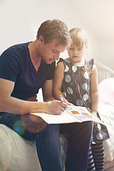 Image showing Dedicated to his daughters education. Shot of a single dad helping his daughter with her homework.