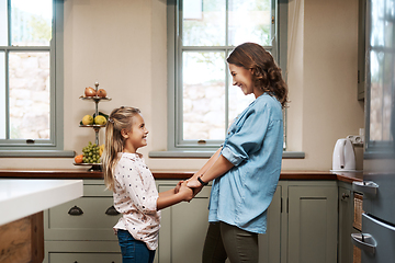 Image showing Being a mom means so much to me. Shot of a young girl and her mother dancing in the kitchen at home.