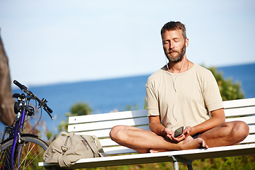 Image showing He cycled to his place of calm. Shot of a mature man listening to music while doing a relaxation exercise outdoors.