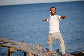 Image showing Warrior by the sea. Shot of a handsome mature man doing yoga beside the ocean.