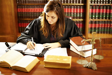 Image showing Shes an expert in the legal world. Shot of a young legal professional sitting at her desk in a study.