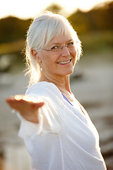 Image showing I always feel better after a yoga workout. Cropped portrait of an attractive mature woman doing yoga on the beach at sunset.