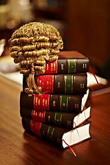 Image showing Knowledge of the law is crucial for a fair trial. Shot of legal books and a wig on top of a table.