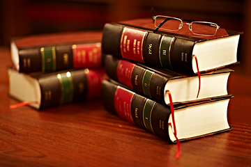 Image showing Get to know your rights. Shot of a stack of legal books and a pair of glasses on a table in a study.