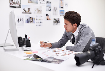 Image showing Making his final selection. A photographer looking at his images in his office.