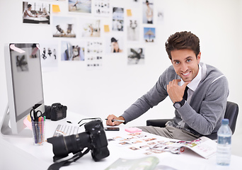 Image showing Making his final selection. A photographer looking at his images in his office.