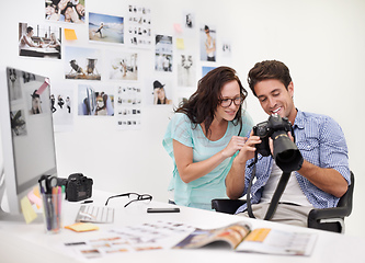 Image showing There are some really great images here. A photographer looking at his images in his office with his assistant.