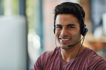 Image showing He upholds the trust and faith in his company. Shot of a young call centre agent working at his desk.