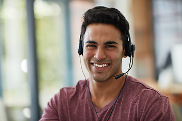 Image showing Always show gratitude for a customers time and business. Shot of a young call centre agent working at his desk.