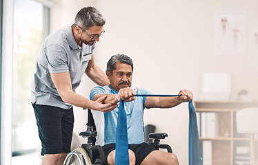 Image showing This exercise is also great for maintaining good balance. Shot of a senior man in a wheelchair exercising with a resistance band along side his physiotherapist.