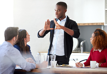 Image showing Take a step back.... Cropped shot of a young businessman addressing his colleagues during a business meeting.