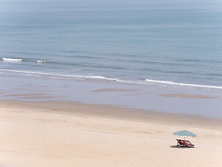 Image showing Deck chairs and parasol on empty beach