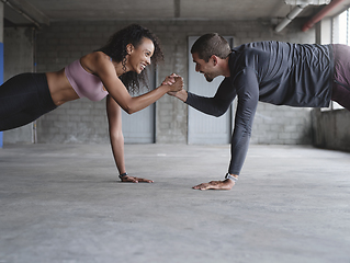 Image showing We can withstand anything together. Shot of a sporty young couple holding hands while exercising together inside an underground parking lot.