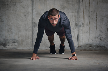 Image showing Your mentality is your biggest strength. Portrait of a handsome young sportsman doing push ups while exercising inside a parking lot.