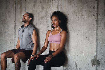 Image showing Balance is the greatest form of strength. Shot of a sporty young couple exercising against a wall inside an underground parking lot.