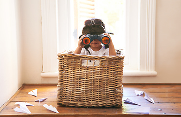 Image showing Clear skies ahead. Shot of an adorable little boy sitting playing in a basket among paper jets.