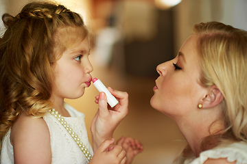 Image showing Dressing up her little princess. Cropped shot of a mother applying lipstick to her little daughter at home.