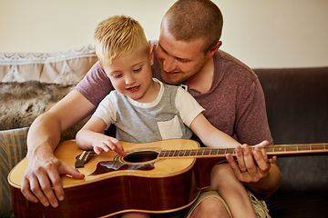 Image showing Time for another guitar lesson with Dad. Cropped shot of a father and his little son playing the guitar together at home.