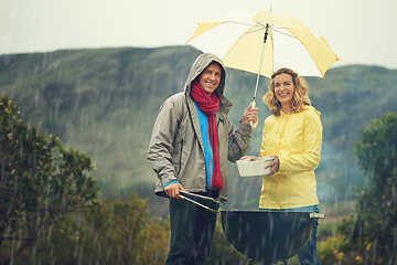 Image showing Come rain or shine. Shot of a couple happily barbecuing in the rain.