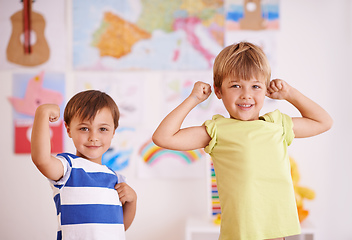 Image showing He wants to be just like his big bro. Two young boys flexing their muscles while standing in their bedroom.