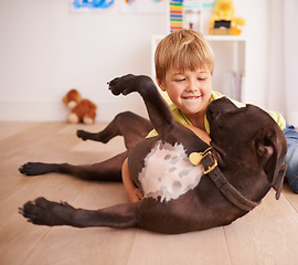 Image showing Every little boy should have his own dog. A little boy playing with his dog in his room.