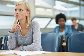 Image showing Focused on her future. A beautiful young student listening intently in a lecture hall.