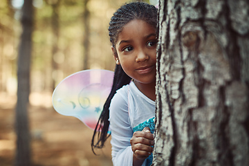 Image showing Can you spot a cute fairy in the forest. Shot of a little girl dressed up as a fairy and playing in the woods.