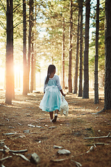 Image showing On an exploration of the wonders of the woods. Rear view shot of a little girl walking in the woods with her teddybear.