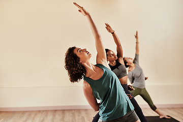 Image showing Life is all about balance. Shot of a group of young men and women practicing yoga in a fitness class.