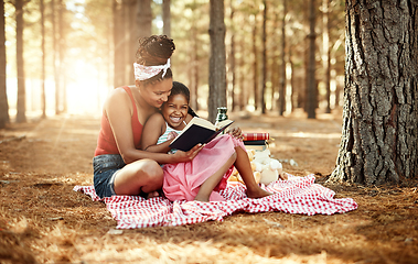 Image showing Spark your childs imagination and stimulate curiosity through reading. Shot of a mother and her little daughter reading a book together in the woods.