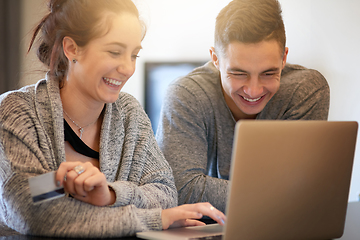 Image showing Spending some money online. Shot of an affectionate young couple surfing the net while relaxing on the sofa at home.