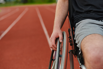 Image showing Close up photo of a person with disability in a wheelchair training tirelessly on the track in preparation for the Paralympic Games