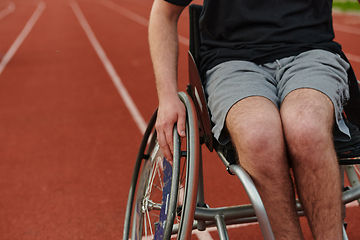 Image showing Close up photo of a person with disability in a wheelchair training tirelessly on the track in preparation for the Paralympic Games