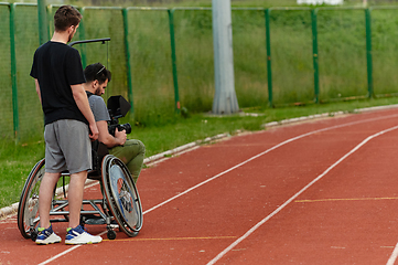 Image showing A cameraman filming the participants of the Paralympic race on the marathon course