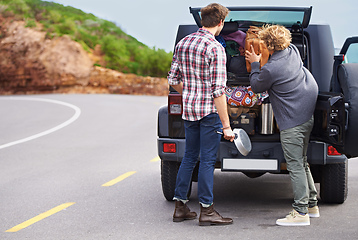 Image showing We need a bigger truck. Shot of a two people stopped at the side of the road and repacking their truck.