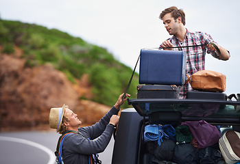 Image showing Think we brought too much. Shot of two young men stopped at the side of the road and repacking their truck.