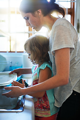 Image showing Helping to get the dishes clean. Shot of a mother and daughter washing dishes together.