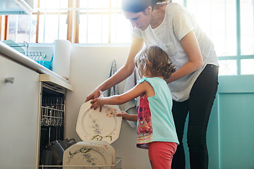 Image showing One plate at a time. Shot of a mother and daughter busy at a dishwashing machine.