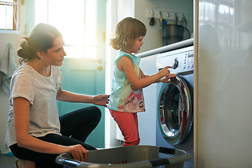 Image showing She knows which buttons to press. Shot of a mother and daughter using a washing machine.