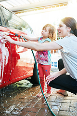 Image showing Spending some quality time together. Shot of a mother and daughter washing a car together.