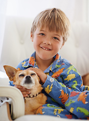 Image showing Snuggling his old friend. A cute little boy cuddling his dog on the couch.