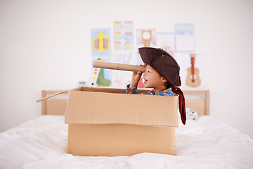 Image showing Shiver me timbers. A little pirate spying land from his cardboard box boat.