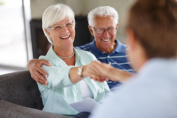 Image showing Ill shake on that.... Over-the-shoulder shot of a financial advisor meeting with a senior couple at their home.