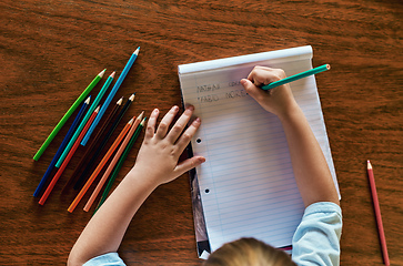 Image showing I can write my name. High angle shot of a little boy sitting at a desk and writing on a notepad.